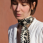 Seidenband schwarz beige gemustert um Hals gebunden