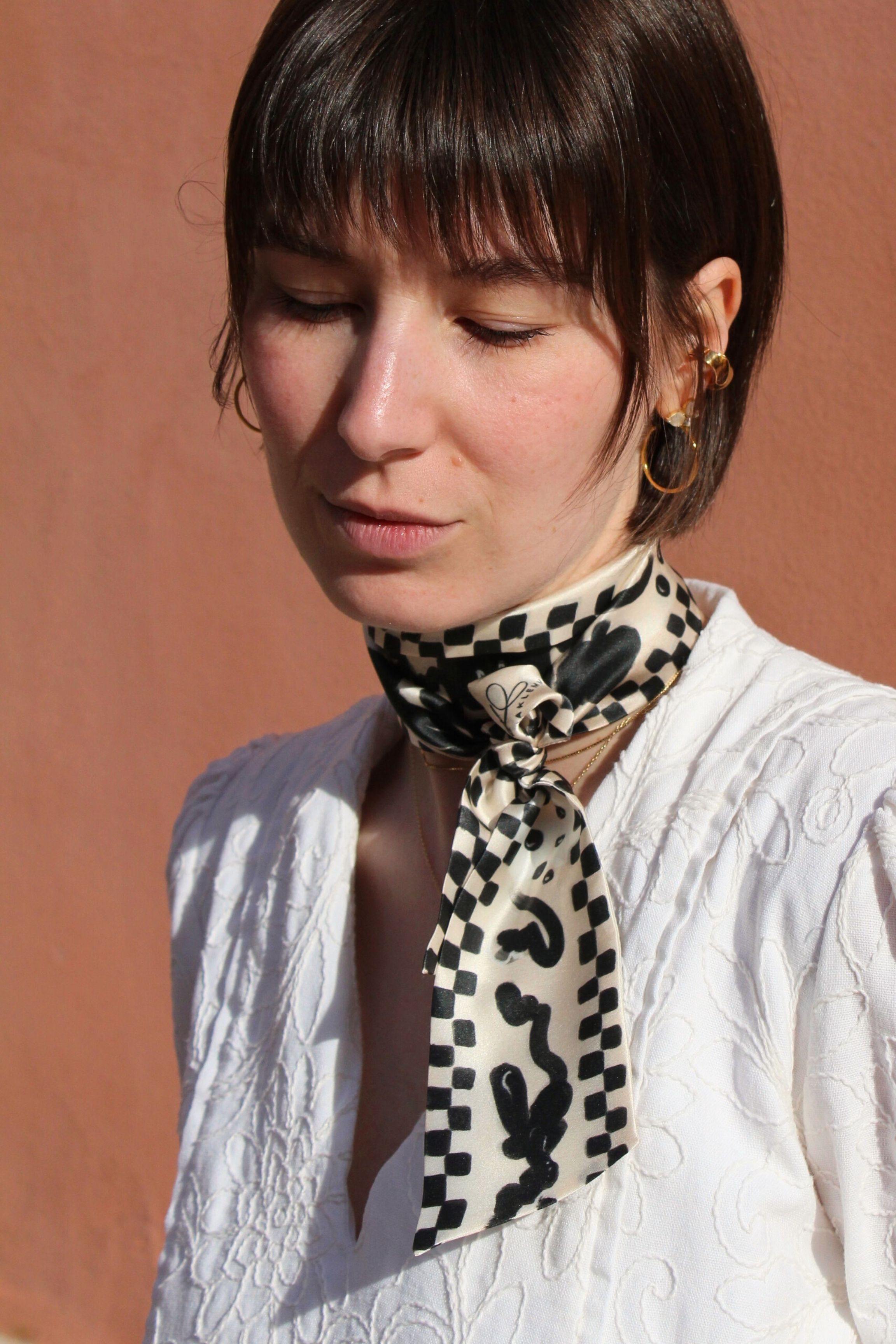 Seidenband schwarz beige gemustert um Hals gebunden